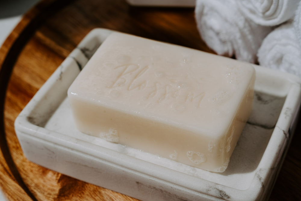 Bar of blossom goat's milk soap in soap dish